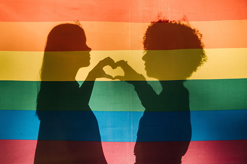 mental health foundation articles lgbtq mental health image of a silhouette of two women on rainbow flag